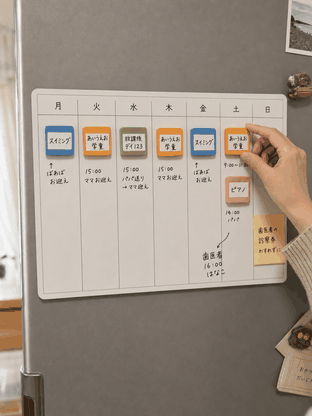 冷蔵庫のホワイトボードに磁石を並べた週間予定